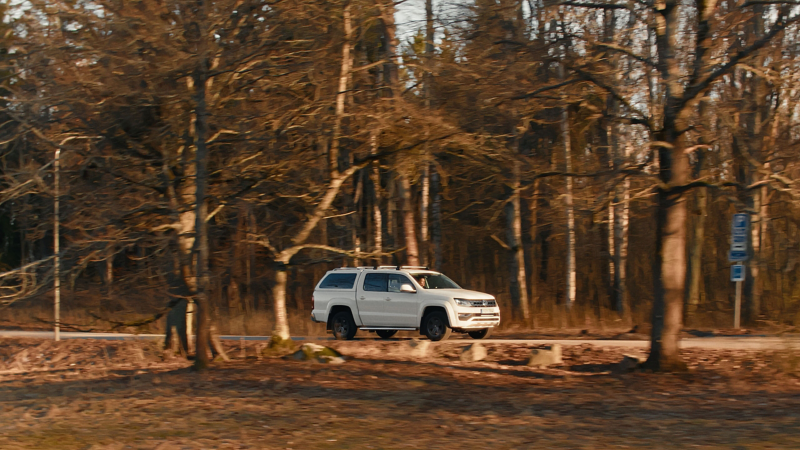 En vit VW Amarok kör längs en landsväg