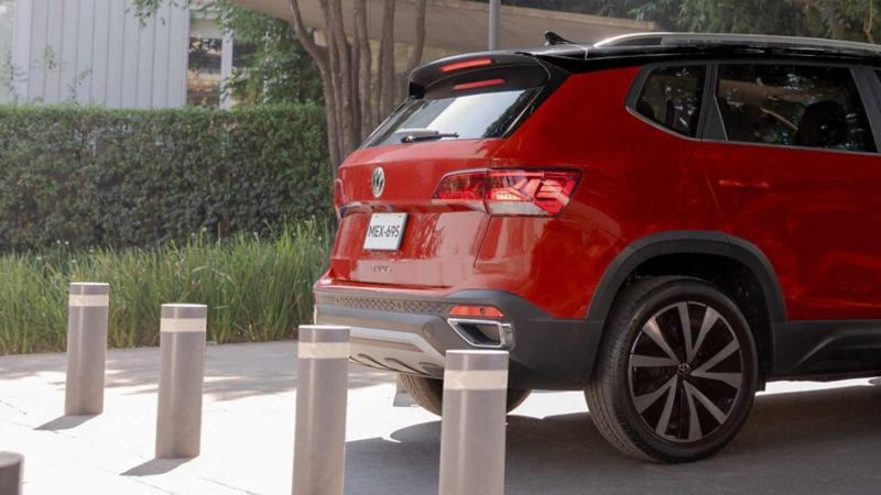 Camioneta Taos de Volkswagen. Cajuela y faros traseros de SUV en color rojo y techo negro.