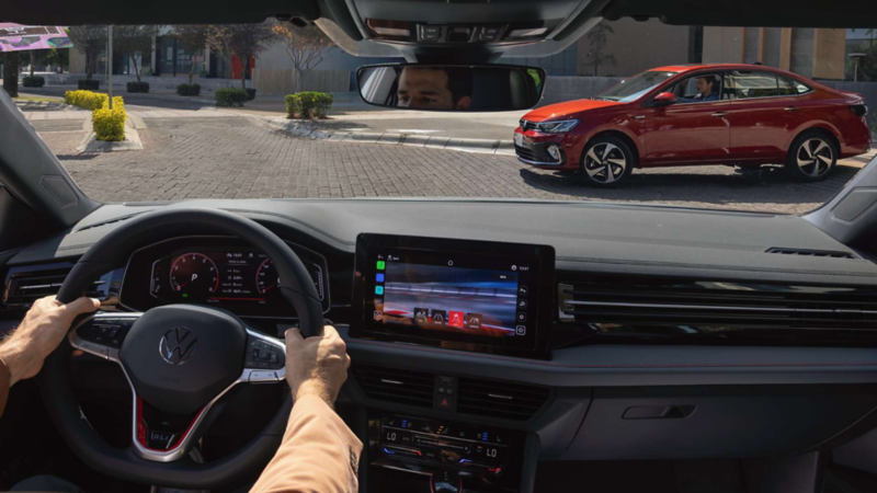 Interior de un auto Volkswagen. Vista al parabrisas, panel de control y pantalla táctil. 