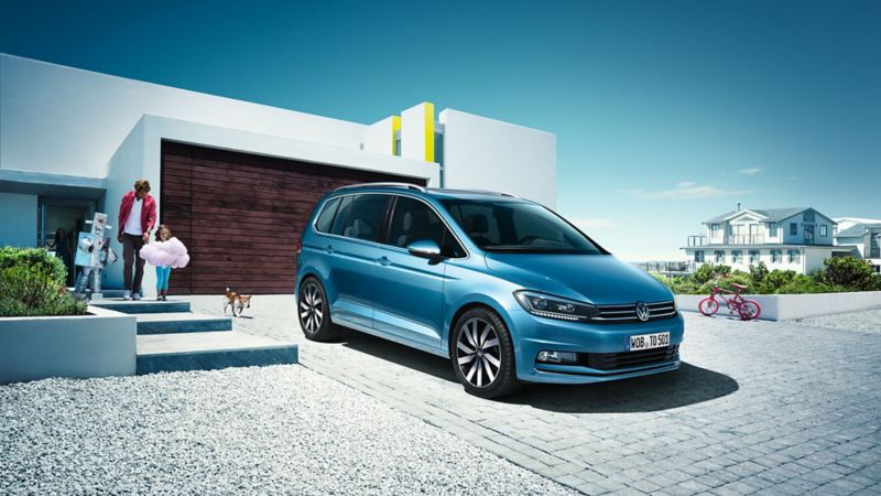 Une famille marche vers un Volkswagen Touran