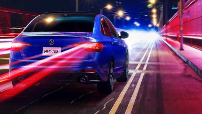 Jetta GLI de Volkswagen en color azul dentro de calle durante la noche. 