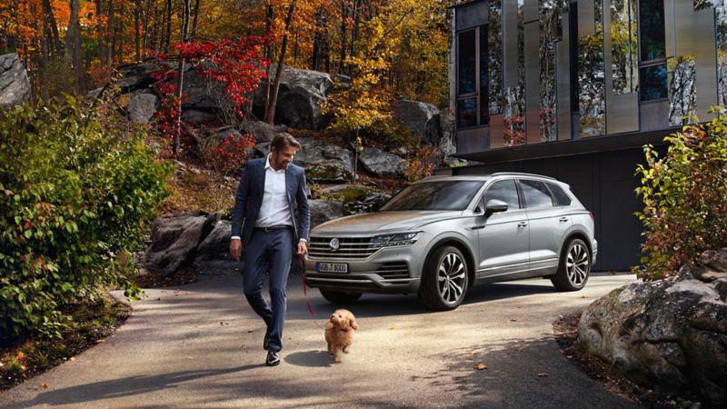 VW Touareg avec un homme et son chien devant
