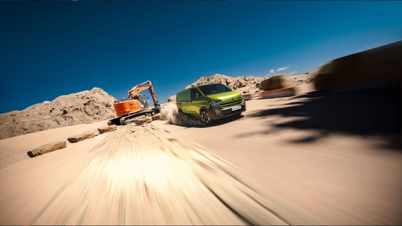 Photo of a green Transporter driving next to a digger