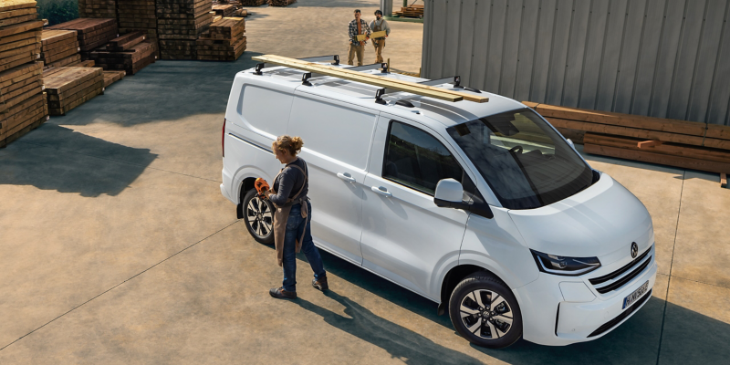 En kvinna står bredvid sin VW e-Transporter