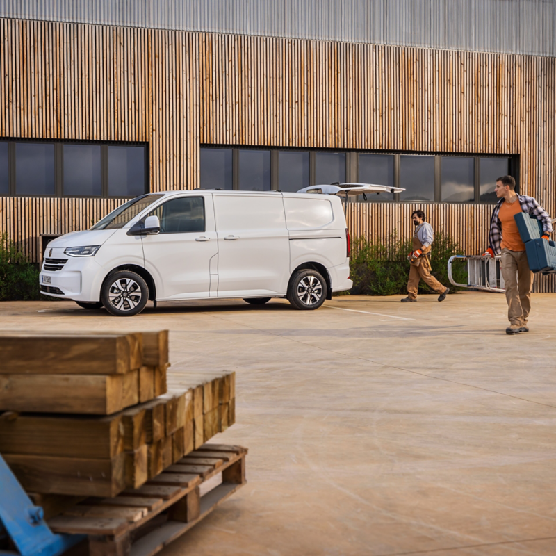 Rzemieślnicy rozładowują materiał z VW Transportera Furgon.
