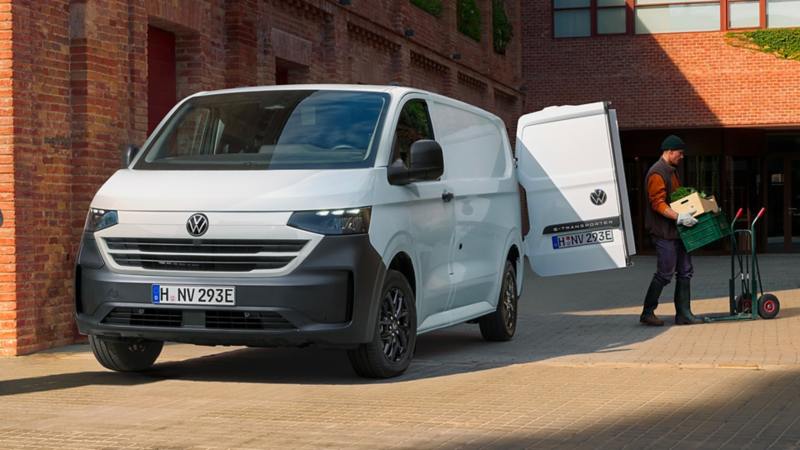 Persona scarica cassee da un VW Tranporter Van.