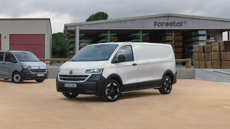 VW Transporter Kastenwagen parkt vor einer Lagerhalle.