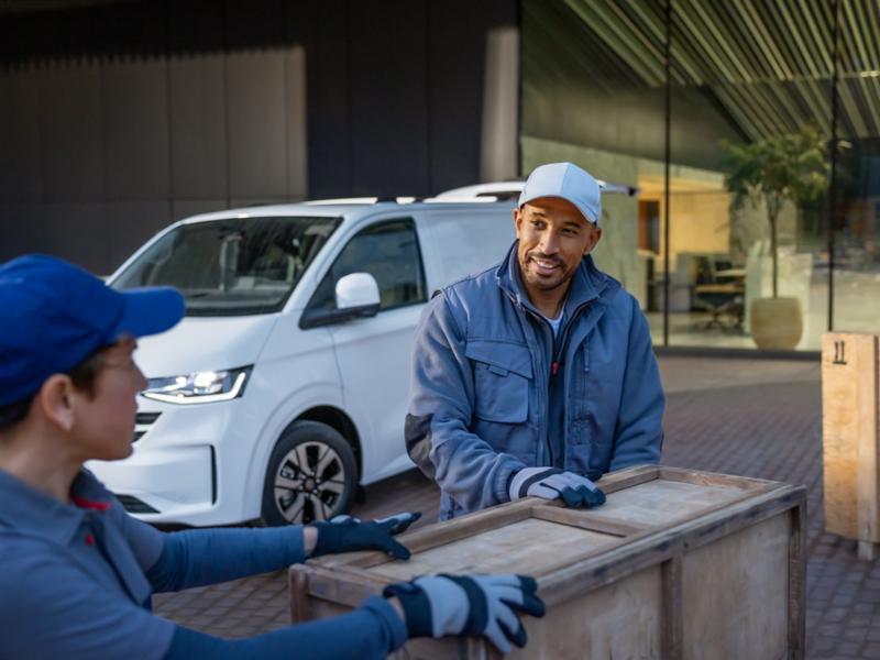 Handwerker verzurren eine Marmorplatte auf der Ladefläche des VW Pritschenwagen.