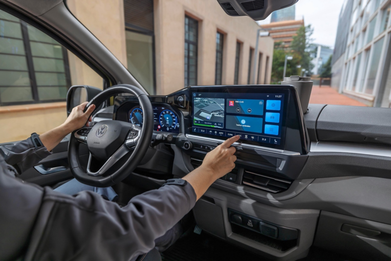 El VW Nuevo California aparcado en la orilla junto a dos personas.
