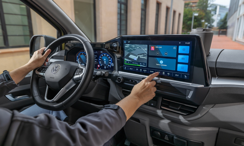 Nahaufnahme des Cockpits eines VW Transporters, auf dem Boardcomputer wird das Navigationssystem eingestellt.