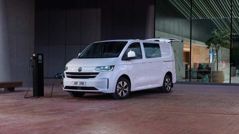 Exterior photo showing the new Transporter Kombi parked outside of a modern office building.