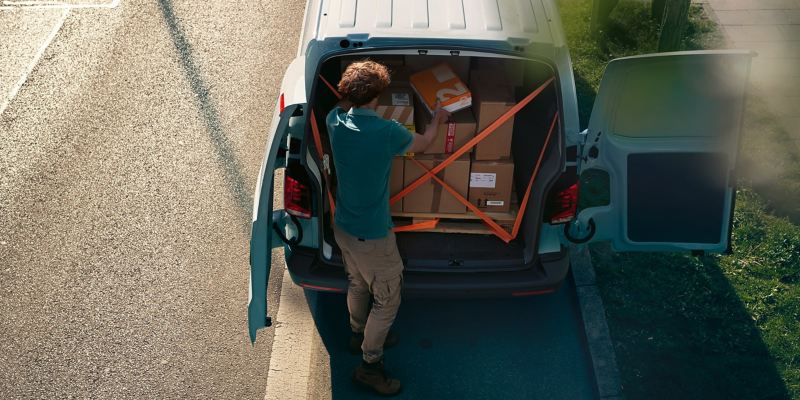 Pakete werden in einem VW Transporter 6.1 verladen.
