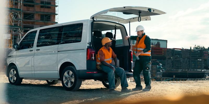 Due operai discutono dietro a Volkswagen Transporter Kombi