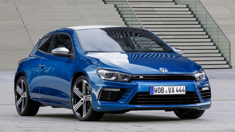 Le Scirocco R dernière génération dans son bleu traditionnel, montre son design musclé et sportif sur un parvis bétonné.