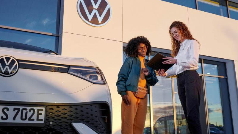 Dos chicas junto a un Volkswagen blanco