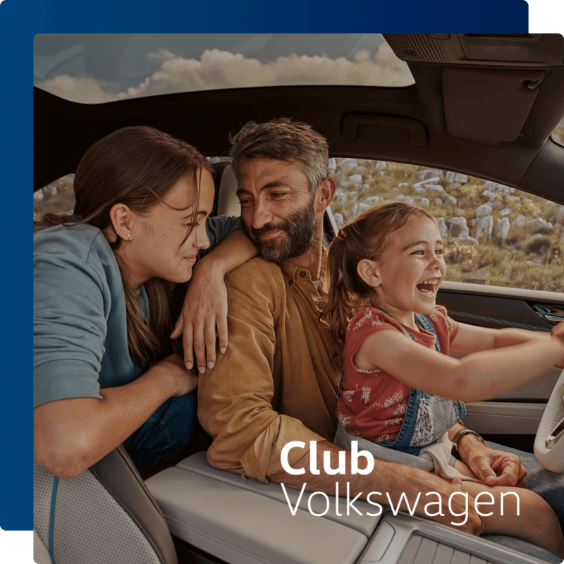 Una familia feliz sentada en el interior de un Volkswagen