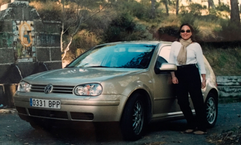 Una mujer apoyada en un Golf Volkswagen gris vintage
