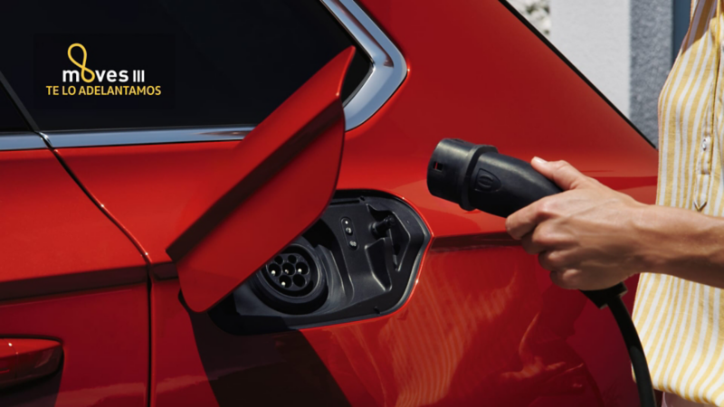 Detalle de la carga de un Volkswagen eléctrico con logo plan moves