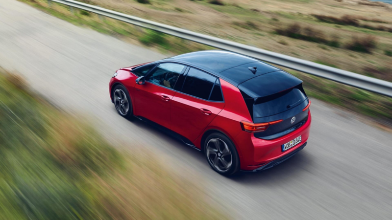 Un Volkswagen ID.3 rojo a gran velocidad por una carretera rural