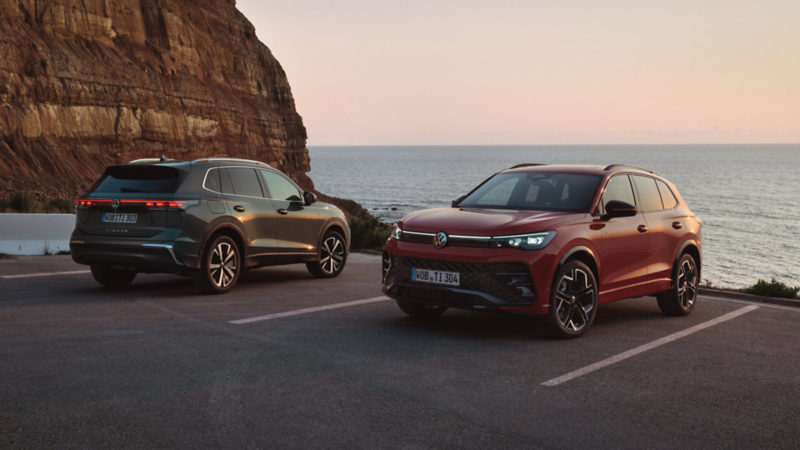 Dos Volkswagen Tiguan estacionados en un aparcamiento al lado del mar