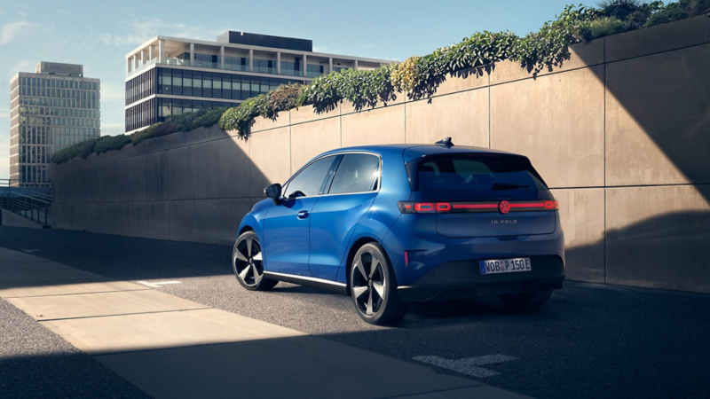 Un Volkswagen ID. Polo azul vista lateral trasera  junto pared hormigón 