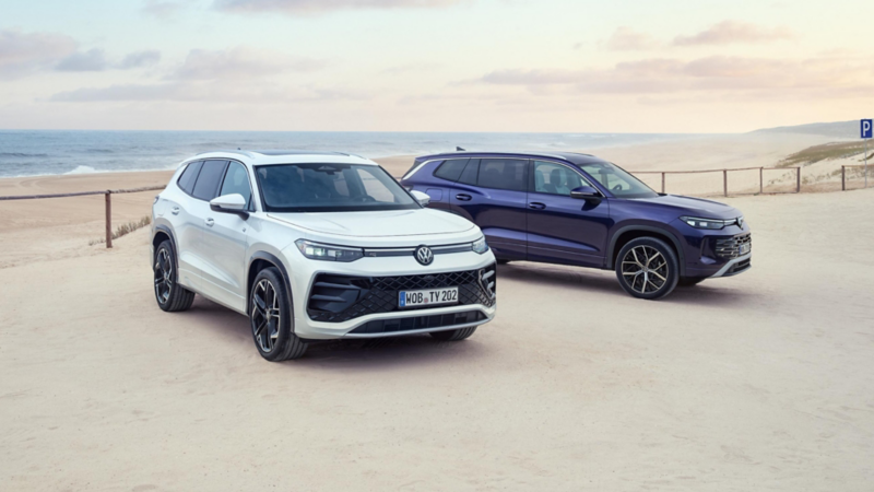 Dos Volkswagen Tayron de color blanco y azul estacionados en una playa