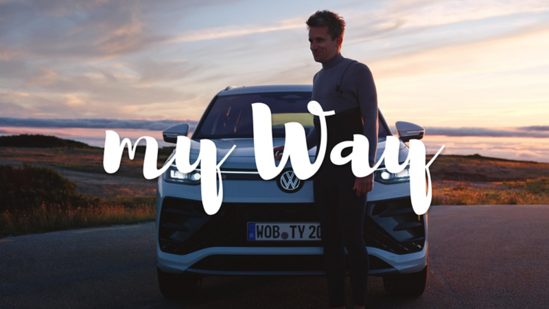 Un chico delante de un Volkswagen Tayron de color blanco con el logo de My Way