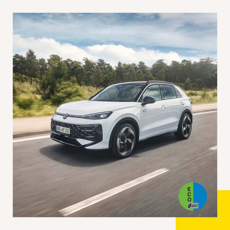 Un Nuevo T-Roc blanco en una autopista y la etiqueta ECO de la DGT