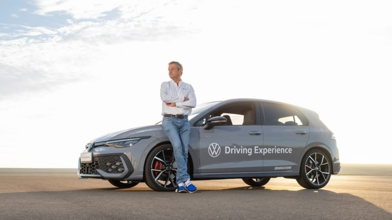 Luis Moya apoyado sobre un Volkswagen que dice Driving Experience