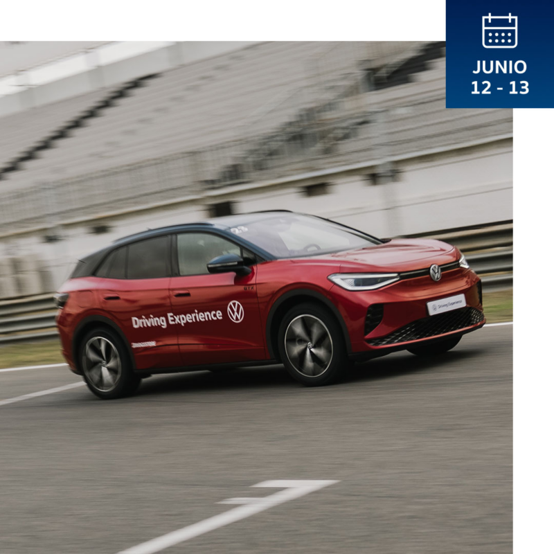Un Volkswagen rojo con techos negros en movimiento en el circuito de Jarama con Driving Experience