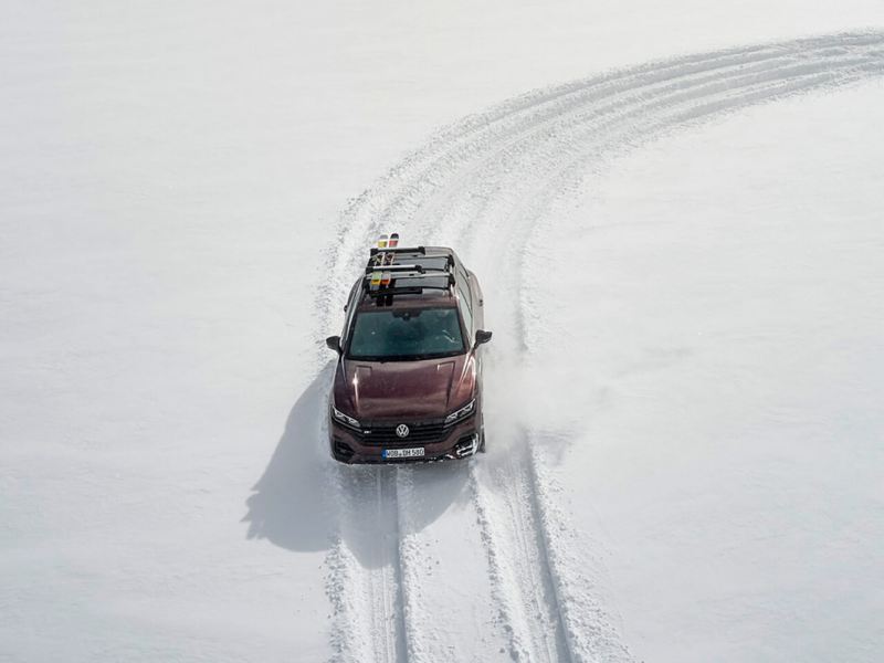 Volkswagen Touareg con dirección en las cuatro ruedas trazando una curva en la nieve