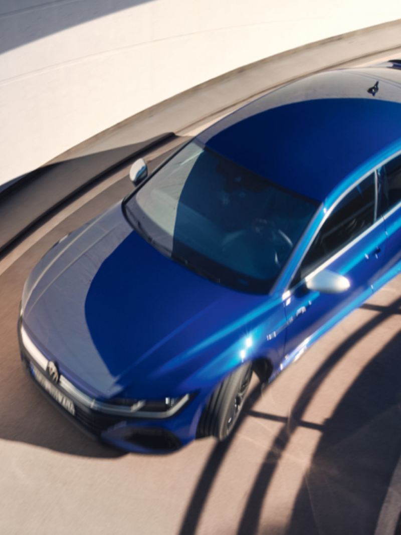 Vista desde arriba del Nuevo Volkswagen Arteon R azul bajando por una rampa