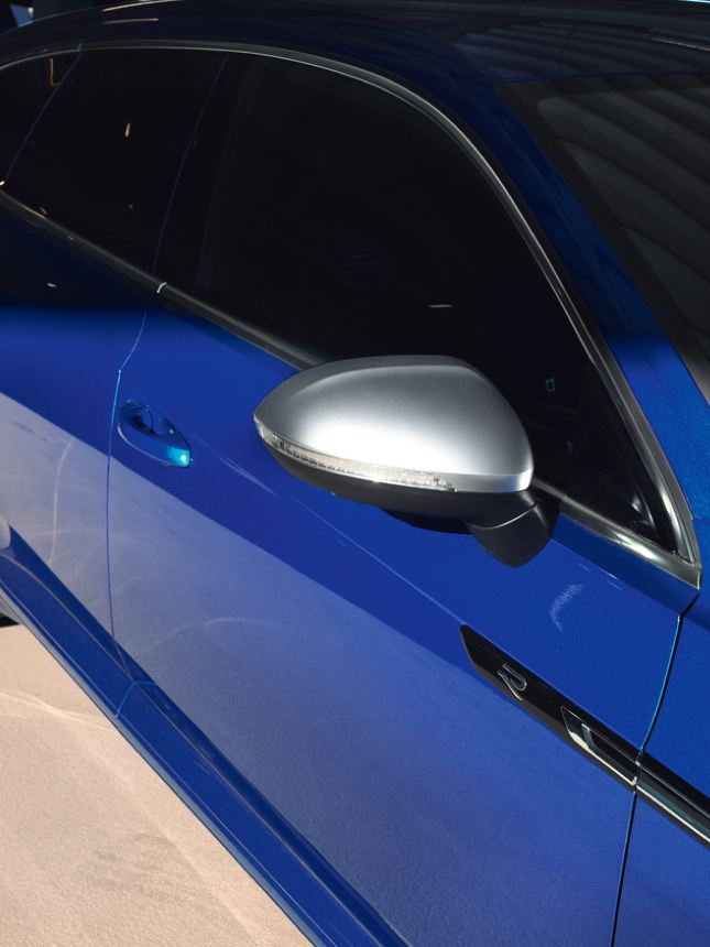 Detalle de un espejo retrovisor y el costado de un Nuevo Volkswagen Arteon Shooting Brake R azul