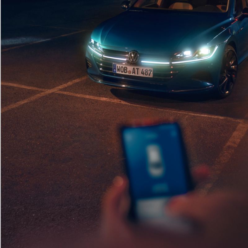 Vista subjetiva de la aplicación We Connect junto a un Nuevo Volkswagen Arteon R azul