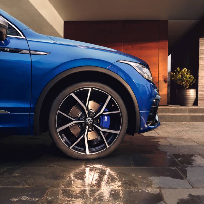 Rueda delante de un Volkswagen Tiguan azul con el logotipo R en la rueda.