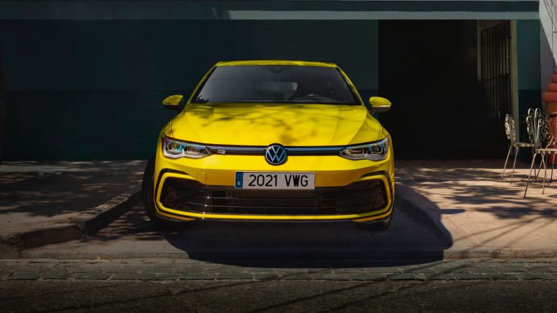 Volkswagen Golf 8 amarillo visto de frente aparcado bajo la sombra de un árbol