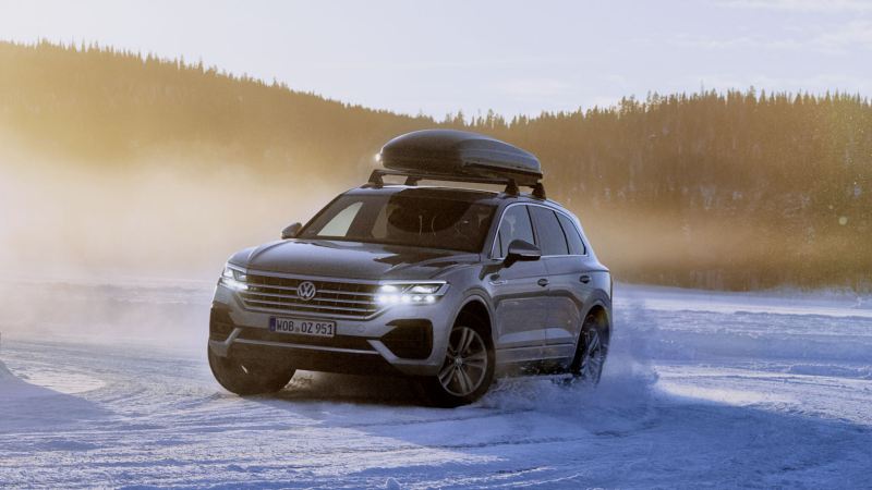 Volkswagen Touareg visto de frente por la nieve con baúl portaequipaje