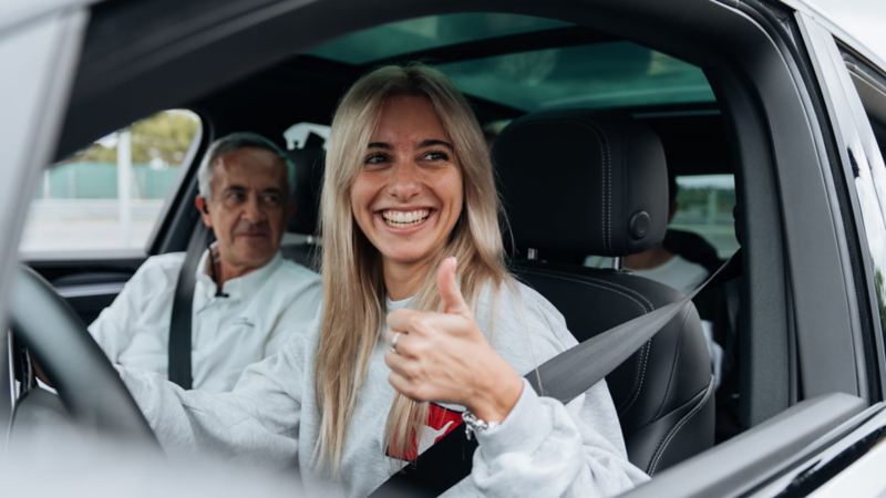 Una chica con un instructor dentro de un Volkswagen en una sesión de Driving Experience