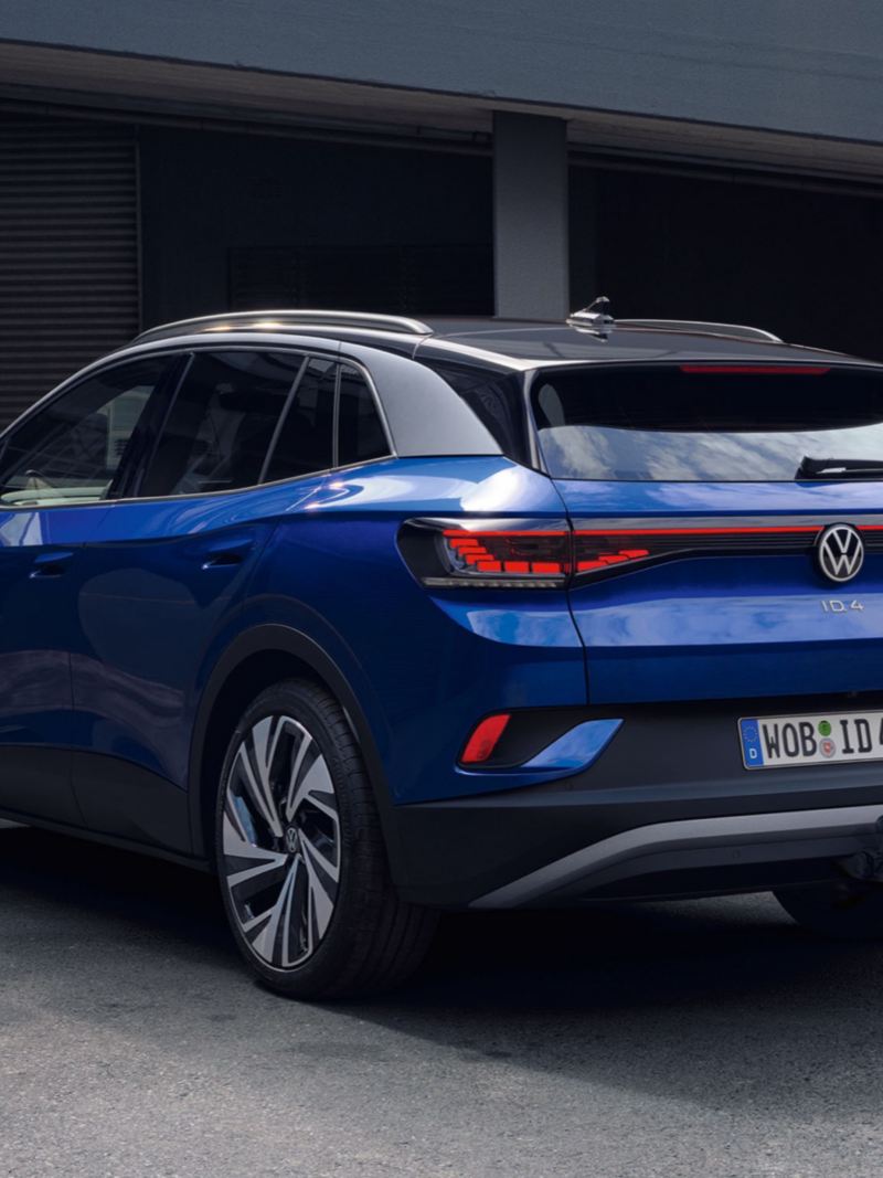 Volkswagen ID.4 azul visto desde atrás aparcado en una casa