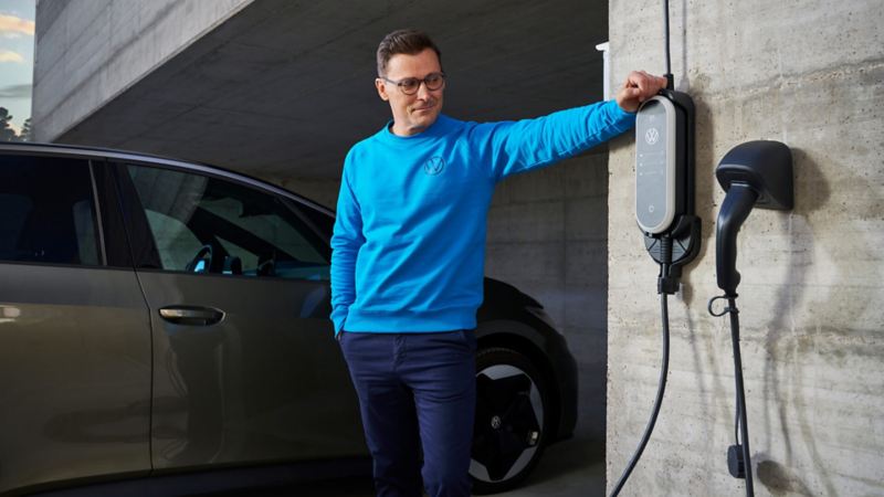 Un hombre junto al punto de carda de un coche Volkswagen