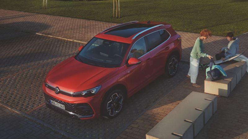 Un Volkswagen Tiguan rojo estacionado en una plaza de aparcamiento en la calle