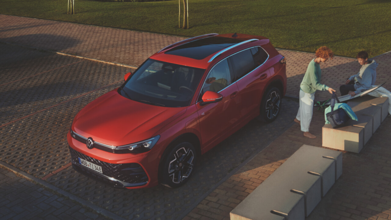 Un Volkswagen Tiguan rojo estacionado en una plaza de aparcamiento en la calle