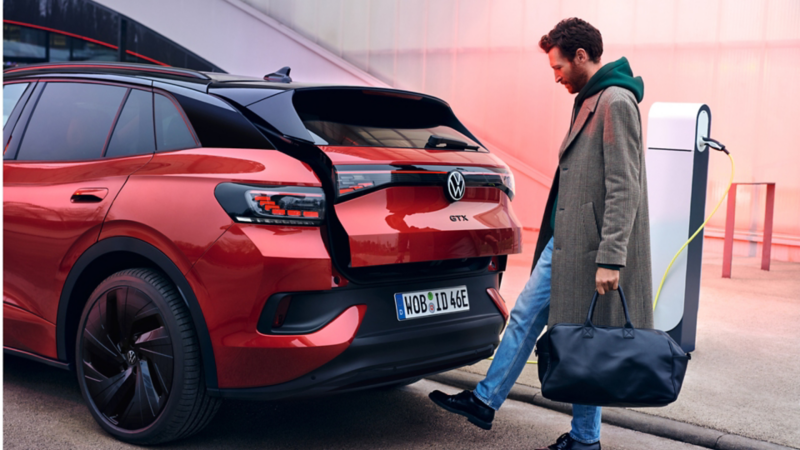 Un hombre abriendo el portón trasero de un Volkswagen ID.4 GTX moviendo el pie