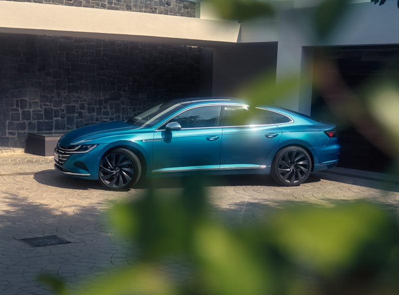 Arteon azul aparcado delante de una casa