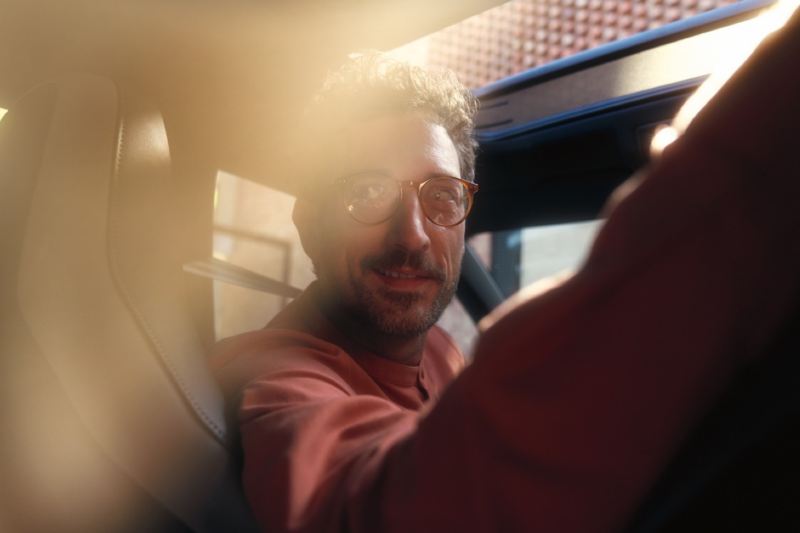 Hombre con gafas girándose sentado en el asiento del conductor de un Arteon Shooting Brake