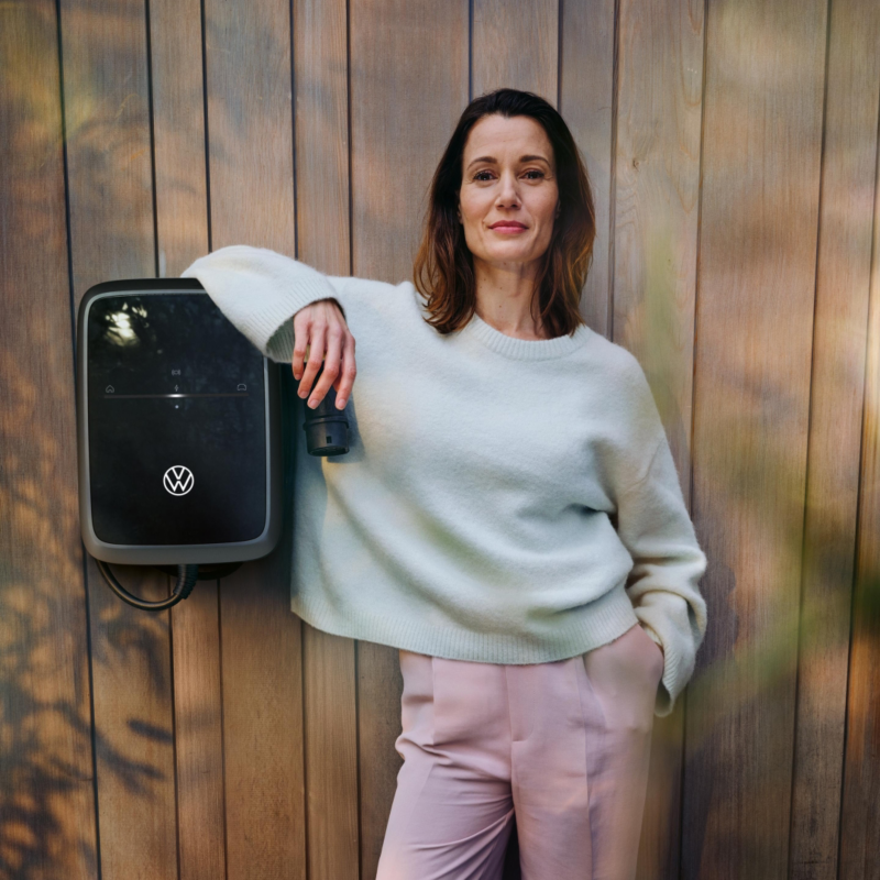 Chica apoyada en un Wallbox en una pared de madera