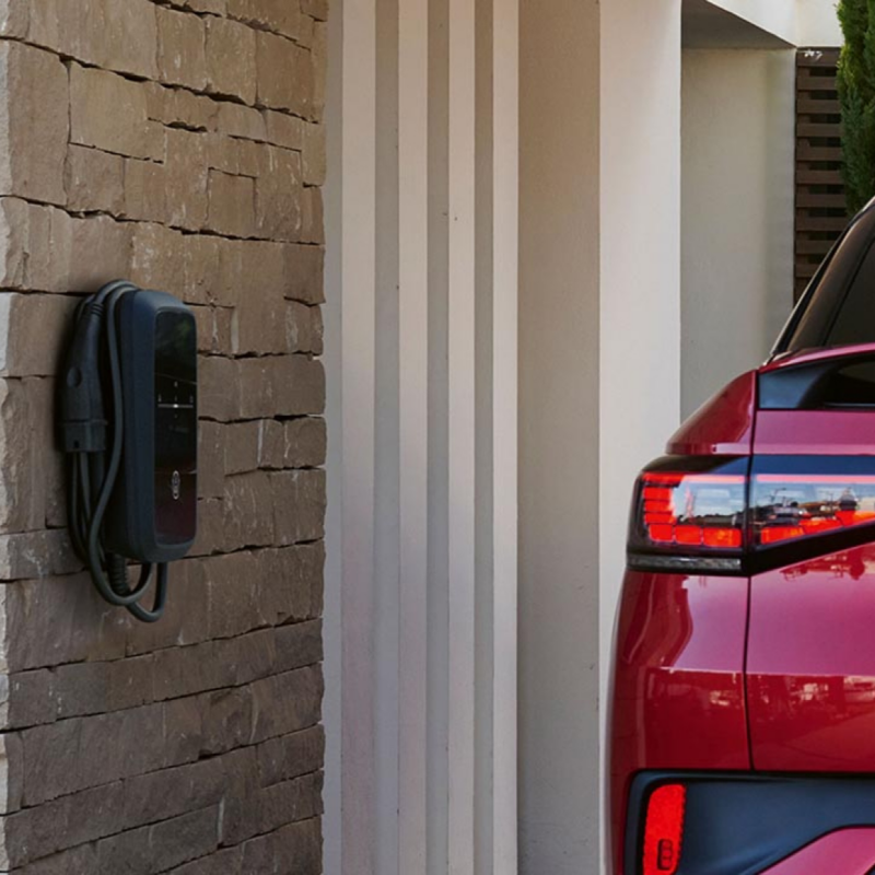 Volkswagen de color rojo visto parcialmente conectado a un cargador