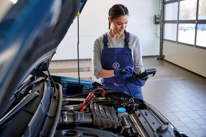 Una mecánico arreglando un Volkswagen