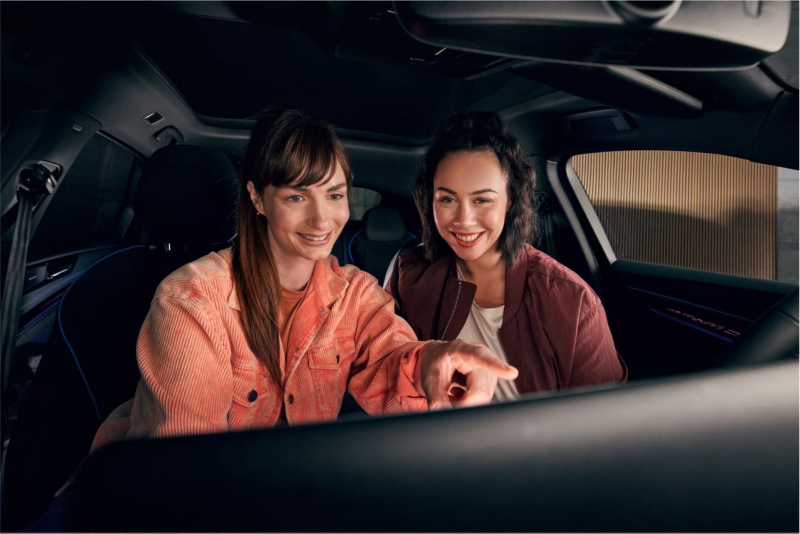 Dos chicas sentadas dentro de un coche eléctrico de Volkswagen