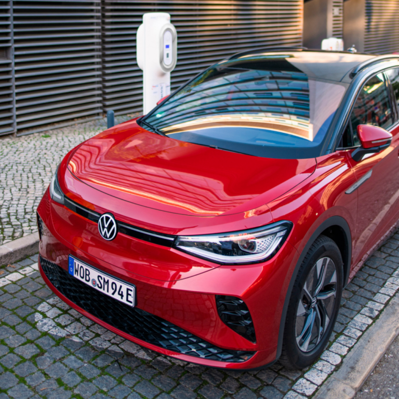 Volkswagen ID.4 rojo aparcado en la calle en una estación de carga